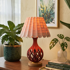 Decorative lamp with a unique design on a table with plants and books in a home setting