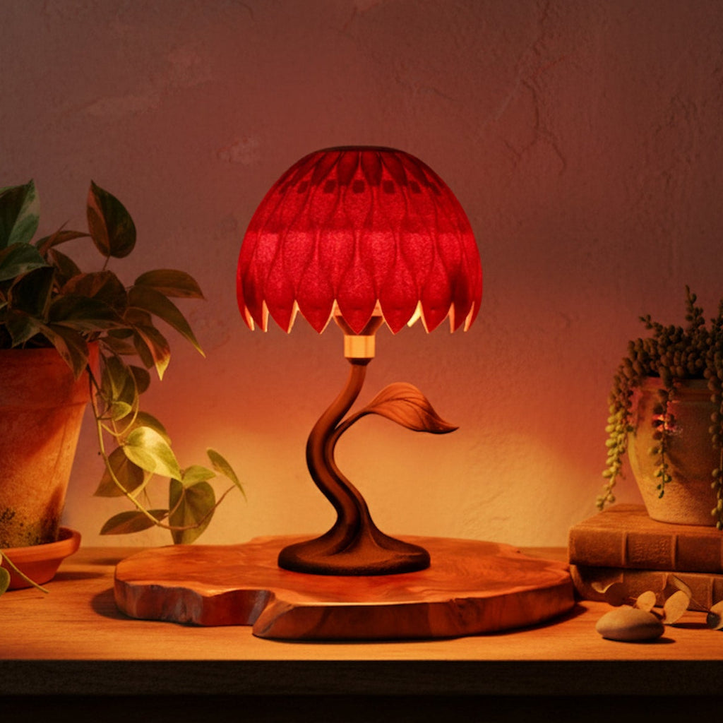 Red lamp with wooden base on a table with plants in the background