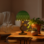 Green table lamp on a wooden table with plants and books in a cozy room.