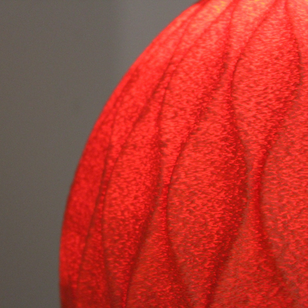 Close-up of a textured red surface with a blurred gray background