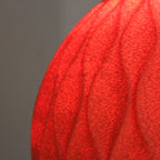 Close-up of a textured red surface with a blurred gray background